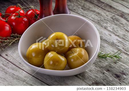 Pickled green tomatoes in the bowl 138234903