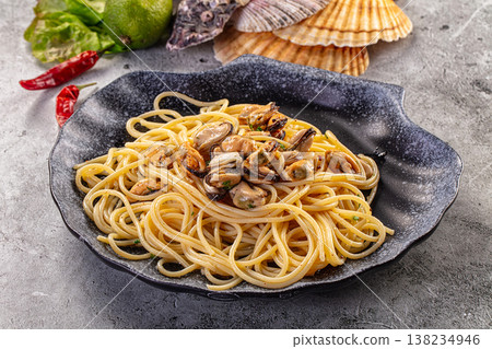 Spaghetti with mussels in a black ceramic plate with fresh ingredients Spaghetti with mussels in a black ceramic plate with fresh ingredients 138234946