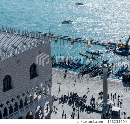 Sunlit Venetian waterfront with gondolas and tourists Sunlit Venetian waterfront with gondolas and tourists 138235394