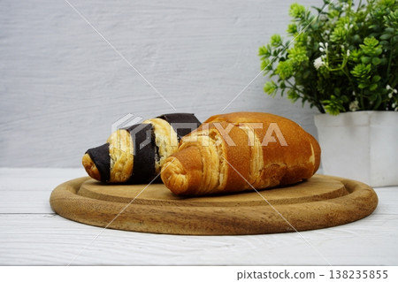 Fresh and tasty croissants on wooden plate 138235855