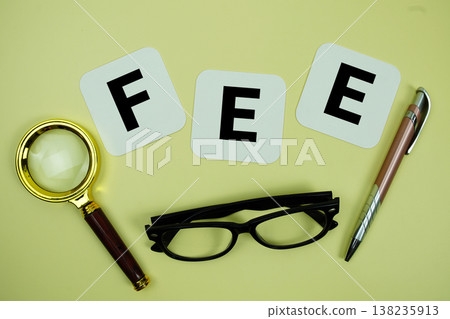 FEE alphabet letters with magnifying glass, eye glasses and pen on yellow background FEE alphabet letters with magnifying glass, eye glasses and pen on yellow background 138235913