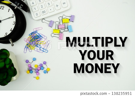 Multiply Your Money message with calculator, alarm clock and Stationery on white background 138235951