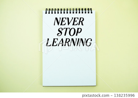 Notepad with message "Never Stop Learning" top view on yellow background 138235996
