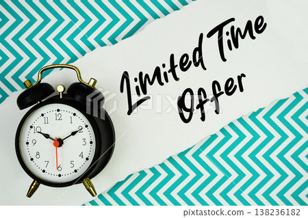 Limited Time Offer text written on paper rip with alarm clock flat lay on turquoise chevron background Limited Time Offer text written on paper rip with alarm clock flat lay on turquoise chevron background 138236182