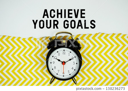 Achieve Your Goals text written on paper with alarm clock on yellow chevron background 138236273