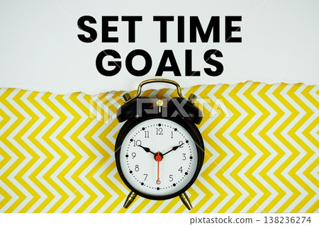 Set Time Goals text written on paper with alarm clock on yellow chevron background Set Time Goals text written on paper with alarm clock on yellow chevron background 138236274