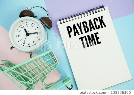 Payback Time text written on notepad with alarm clock and trolley shopping cart Payback Time text written on notepad with alarm clock and trolley shopping cart 138236360