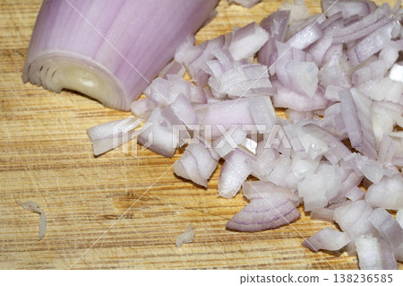 Close up of a chopped shallot onion on a wooden chopping board 138236585