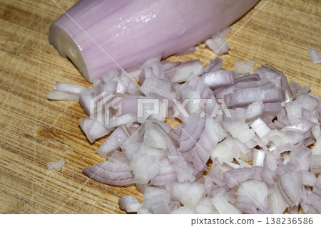 Close up of a chopped shallot onion on a wooden chopping board 138236586