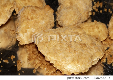 Close up of breaded fish scampi pieces on a tin foil base ready for cooking 138236603
