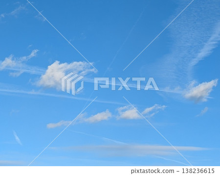 Beautiful blue summer air with fluffy white clouds and chem trail lines across the sky 138236615