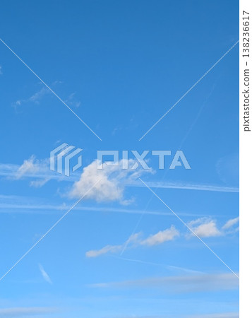 Beautiful blue summer air with fluffy white clouds and chem trail lines across the sky 138236617