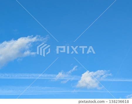 Beautiful blue summer air with fluffy white clouds and chem trail lines across the sky 138236618