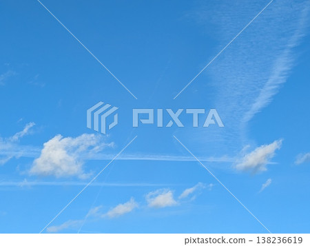 Beautiful blue summer air with fluffy white clouds and chem trail lines across the sky 138236619