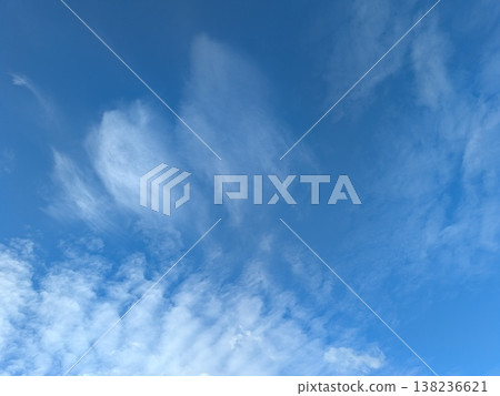 Beautiful blue summer air with fluffy white clouds and chem trail lines across the sky Beautiful blue summer air with fluffy white clouds and chem trail lines across the sky 138236621