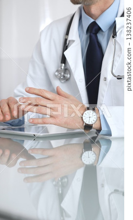 Doctor discussing medical information, explaining diagnosis and treatment to a patient in a consultation room. Medicine and health care 138237406