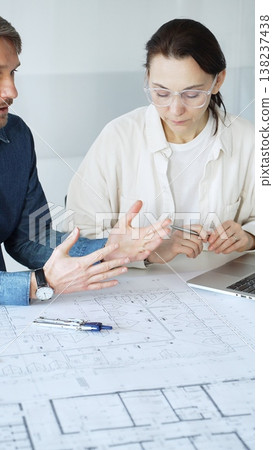 Architects collaborating on architectural project, discussing building design plans, creating new house models, developing urban construction schemes, working in modern office 138237438