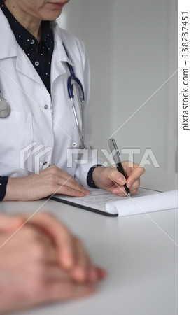 Experienced female doctor consulting patient man, providing medical advice and writing prescription during hospital appointment. Medicine, healthcare and science concept 138237451