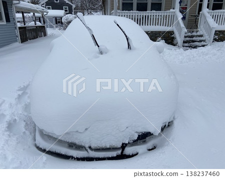 Close-up of a car buried in snow and a winter scene of houses in heavy snow. Close-up of a car buried in snow and a winter scene of houses in heavy snow. 138237460