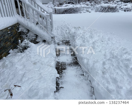 Snow-covered pathways and snow-covered front entrances of houses after heavy snowfall. 138237464