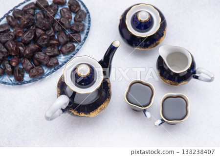 Coffee set with decanter, creamer, blue sugar bowl and cups . Vintage tableware. Sweet dates fruit top view table 138238407