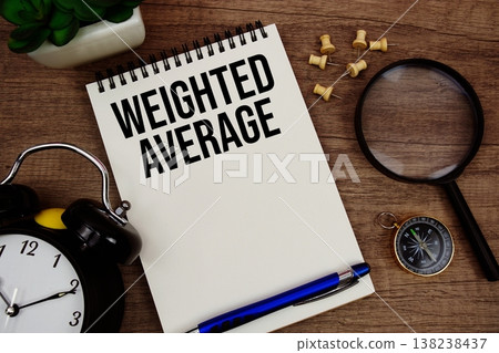 Weighted Average text written on notepad with alarm clock, compass and magnifying glass flat lay on wooden background 138238437