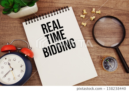 Real Time Bidding text written on notepad with alarm clock, compass and magnifying glass flat lay on wooden background Real Time Bidding text written on notepad with alarm clock, compass and magnifying glass flat lay on wooden background 138238440