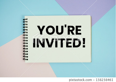 You're Invited! text written on notepad flat lay on multicolor pastel background 138238461
