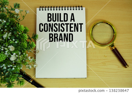 Build a Consistent Brand Message text written on notepad with magnifying glass flat lay on wooden background Build a Consistent Brand Message text written on notepad with magnifying glass flat lay on wooden background 138238647