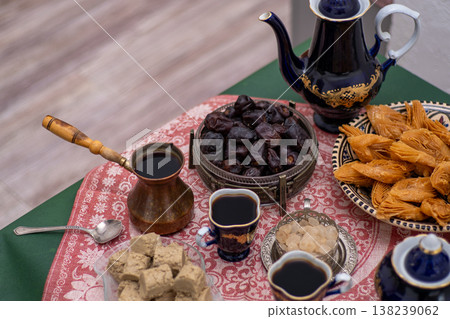 Oriental sweets and coffee cezve on the table. Baklava, halva for dessert. Food and drink. Dates fruit Oriental sweets and coffee cezve on the table. Baklava, halva for dessert. Food and drink. Dates fruit 138239062
