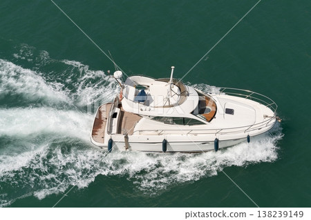 White motor yacht cruising on green sea water 138239149