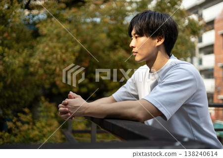 A young man is deep in thought outdoors. A young man is deep in thought outdoors. 138240614