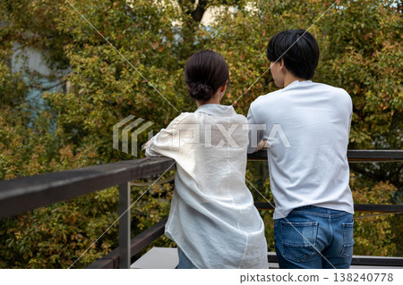 一對年輕男女背影並肩站在陽台上。 138240778