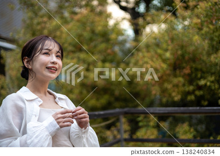 一位年輕貌美的女子站在陽台上。 138240834
