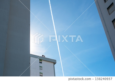 High Angle View of Jet Contrail Over Skyscrapers in Blue Sky High Angle View of Jet Contrail Over Skyscrapers in Blue Sky 138240937