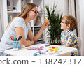 Woman and boy engaging in educational activity at table with colorful learning materials 138242312