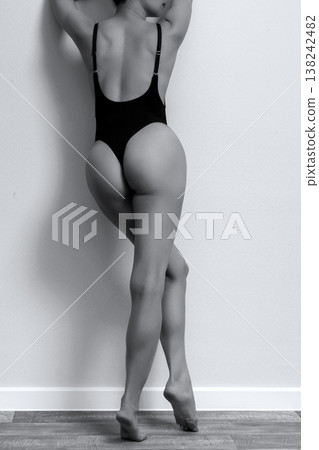 Young adult woman in black lingerie standing by the grey wall Young adult woman in black lingerie standing by the grey wall 138242482