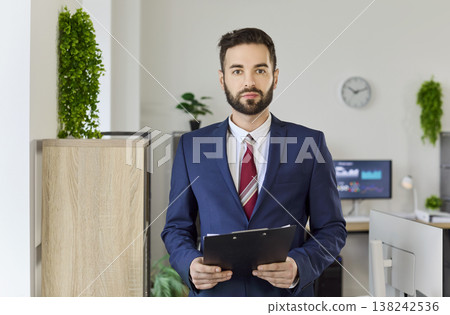 Professional manager with clipboard in modern office, corporate portrait concept Professional manager with clipboard in modern office, corporate portrait concept 138242536