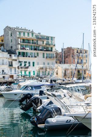 A pastel-colored building with blackout doors bathed in bright sunlight on the French island of Corsica in the Mediterranean Sea. A pastel-colored building with blackout doors bathed in bright sunlight on the French island of Corsica in the Mediterranean Sea. 138242575