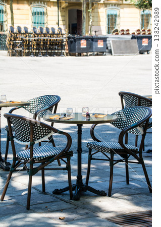 Chairs and tables lined up in a restaurant bathed in bright sunlight; a street scene on the French island of Corsica in the Mediterranean Sea. Chairs and tables lined up in a restaurant bathed in bright sunlight; a street scene on the French island of Corsica in the Mediterranean Sea. 138242989
