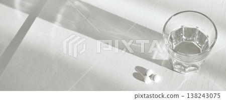 Pills and glass of water on table in morning light, banner format 138243075