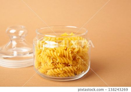 Glass jar with pasta on brown background. fusilli pasta. Glass jar with pasta on brown background. fusilli pasta. 138243269