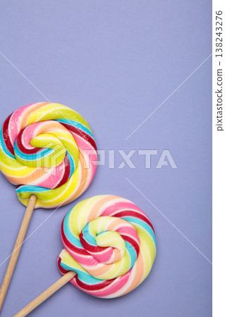 Colorful lollipops on purple background. Vertical photo 138243276