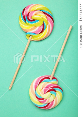 Colorful lollipops on mint background. Vertical photo 138243277