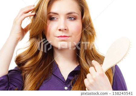 Woman brushing long healthy brown hair Woman brushing long healthy brown hair 138243541