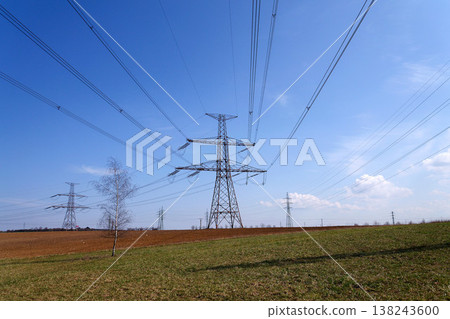 Electricity pylons conducting current from distribution power station, blackout and grid stability concept, copy space 138243600