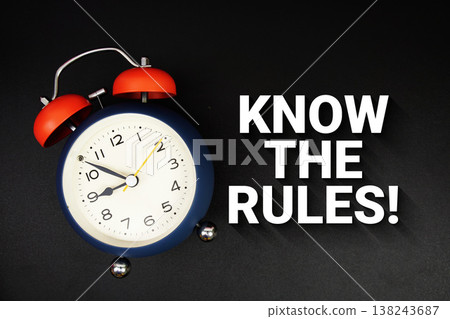 Know The Rules! text with alarm clock on black background Know The Rules! text with alarm clock on black background 138243687