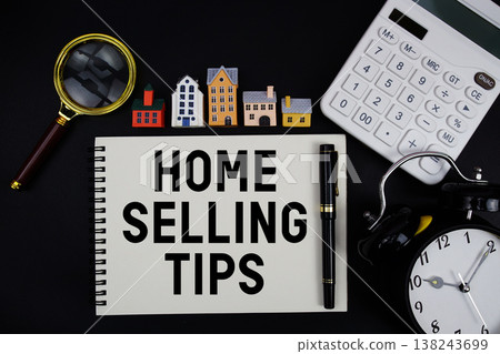 Notepad with the phrase "Home Selling Tips" surrounded by a pen, calculator, magnifying glass, clock, and house model 138243699