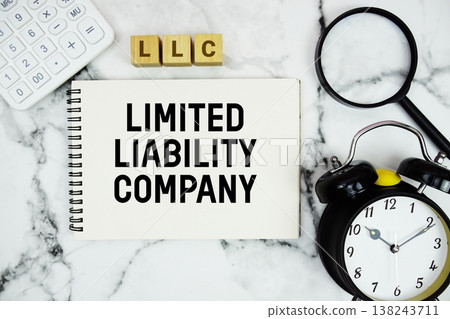 LLC Limited Liability Company text with calculator, magnifying glass and alarm clock on marble background 138243711
