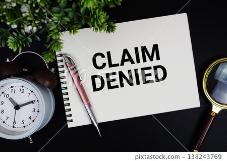 Claim Denied text with alarm clock and magnifying glass 138243769